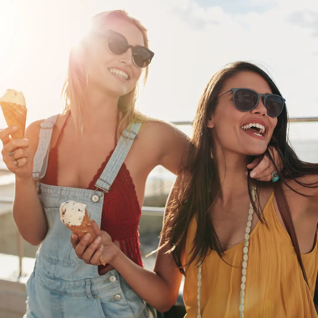 Female friends at beach eating ice-cream